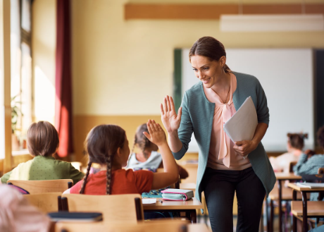 Mentor giving high-five to student in classroom